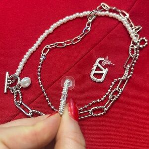 Set/bundle: Very beautiful V logo earrings and faux pearls necklace in silver.